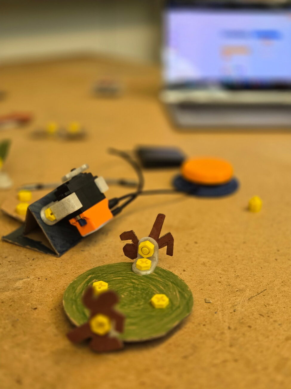 A finished SparkServo build — a servo, an orange button switch, and a hand-crafted creation
